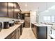 Modern kitchen featuring dark cabinetry, stainless steel appliances, and a center island with seating at 671 Drop Shot Dr, Davenport, FL 33896