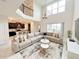 Bright living room with soaring ceilings, a large sectional sofa, and views into the adjacent open-plan kitchen at 671 Drop Shot Dr, Davenport, FL 33896