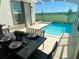 Screened-in pool and hot tub, with table and chairs under covered patio for outdoor dining at 671 Drop Shot Dr, Davenport, FL 33896
