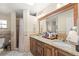 Bathroom with double sinks, granite countertops, shower, and decorative tile accents at 6975 Maverick Trl, St Cloud, FL 34771