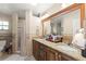 Bathroom with double sinks, granite countertops, shower, and decorative tile accents at 6975 Maverick Trl, St Cloud, FL 34771