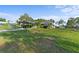 Beautiful home with a covered parking area, lush green lawn, and mature trees on a sunny day at 6975 Maverick Trl, St Cloud, FL 34771