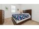 Cozy bedroom with a floral comforter, dresser, and window offering bright, natural light at 7017 Oakwood St, Davenport, FL 33837