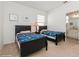 Bedroom with twin beds, a dark wood frame, and a view of the en-suite bathroom at 7017 Oakwood St, Davenport, FL 33837