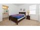 Cozy bedroom with a wooden bed frame, neutral carpet, and natural light from the window at 7017 Oakwood St, Davenport, FL 33837