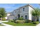 Beautifully landscaped front yard with a two-story home featuring a three-car garage at 7017 Oakwood St, Davenport, FL 33837