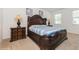 Comfortable main bedroom with dark wood furniture, soft carpet, and bright natural light at 7017 Oakwood St, Davenport, FL 33837