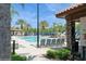 A luxurious outdoor pool features lounge chairs, palm trees, and a covered structure for shade at 7017 Oakwood St, Davenport, FL 33837