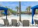Community pool surrounded by palm trees, blue cabanas, and lounge chairs for relaxing at 7017 Oakwood St, Davenport, FL 33837