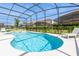 Inviting pool and spa area with clear blue water, perfect for relaxation and recreation in a screened enclosure at 7017 Oakwood St, Davenport, FL 33837