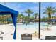 Picturesque community pool featuring lounge chairs, cabanas, a slide, and lush landscaping at 7017 Oakwood St, Davenport, FL 33837
