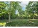 Fenced backyard with a grassy lawn, lush trees and landscaping at 708 Wilson Rd, Winter Springs, FL 32708