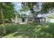 Backyard view of the home, featuring a lush lawn and the enclosed patio on the home at 708 Wilson Rd, Winter Springs, FL 32708