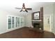 Cozy living room with a brick fireplace, hardwood floors, and natural light from shuttered windows at 708 Wilson Rd, Winter Springs, FL 32708
