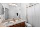 Well-lit bathroom featuring double sinks, a large mirror, and a shower with a white curtain at 714 Home Grove Dr, Winter Garden, FL 34787