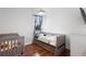 Bright bedroom featuring both a crib and a bed, hardwood floors, and natural light from the window at 714 Home Grove Dr, Winter Garden, FL 34787