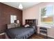 This bedroom boasts a red brick accent wall and a window overlooking the beautiful outdoor pool area at 714 Home Grove Dr, Winter Garden, FL 34787