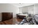 Spacious bedroom with hardwood floors, natural light, and a dark wood dresser and side table at 714 Home Grove Dr, Winter Garden, FL 34787