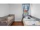 Bright bedroom featuring both a crib and a bed, hardwood floors, and natural light from the window at 714 Home Grove Dr, Winter Garden, FL 34787