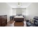 Well-lit bedroom with hardwood floors, two windows, a desk, and a dark wood dresser at 714 Home Grove Dr, Winter Garden, FL 34787