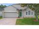 Inviting single-story house boasting a neatly maintained front lawn and a neutral stucco exterior with a green front door at 714 Home Grove Dr, Winter Garden, FL 34787