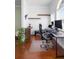 Comfortable home office with wood floors, floating shelves, a large desk setup, and a modern adjustable chair at 714 Home Grove Dr, Winter Garden, FL 34787