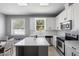 Well-lit kitchen featuring white cabinetry, an island, stainless steel appliances, and modern finishes throughout the space at 714 Home Grove Dr, Winter Garden, FL 34787
