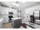 Modern kitchen featuring white cabinetry, an island with seating, stainless steel appliances, and an adjacent dining area at 714 Home Grove Dr, Winter Garden, FL 34787