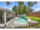 The backyard features a pool, screened in porch, lush grass, and a brick wall at 714 Home Grove Dr, Winter Garden, FL 34787