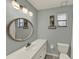Clean bathroom with a single sink vanity and decorative round mirror at 722 Ridgewood Way, Winter Springs, FL 32708