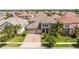 Stunning aerial view of a home with a tile roof, three-car garage, and lush landscaping at 8419 Pippen Dr, Orlando, FL 32836