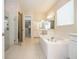 Bright bathroom with soaking tub, glass shower, double vanity, and walk-in closet at 8419 Pippen Dr, Orlando, FL 32836