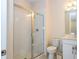 Bright bathroom featuring a glass-enclosed shower, toilet, and vanity with storage at 8419 Pippen Dr, Orlando, FL 32836