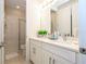 Well-lit bathroom with double vanity, quartz counters, modern fixtures, and a tiled shower at 8419 Pippen Dr, Orlando, FL 32836