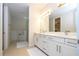 Bright bathroom with double sink vanity, framed mirror, and separate shower and bathtub at 8419 Pippen Dr, Orlando, FL 32836