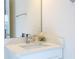 Close-up of a bathroom vanity with a white countertop, chrome faucet, and decorative mirror at 8419 Pippen Dr, Orlando, FL 32836