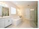 Well lit bathroom with large soaking tub, double vanities, and a glass-enclosed shower at 8419 Pippen Dr, Orlando, FL 32836