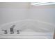 Close-up of a modern soaking tub with chrome fixtures and white tiled surround at 8419 Pippen Dr, Orlando, FL 32836