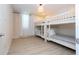 White bunk beds with window and sheer curtains in a well-lit room with light wood flooring at 8419 Pippen Dr, Orlando, FL 32836