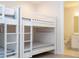 White bunk beds with window and sheer curtains in a well-lit room with light wood flooring at 8419 Pippen Dr, Orlando, FL 32836