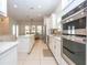 A bright, white kitchen features stainless steel appliances and an island, flowing into an adjacent dining area at 8419 Pippen Dr, Orlando, FL 32836