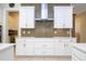 A modern kitchen boasts white cabinets, countertops, stainless steel range hood, and a pot filler faucet at 8419 Pippen Dr, Orlando, FL 32836
