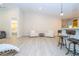 Open living space with light wood floors, a bar with seating, and a view into the bedroom at 8419 Pippen Dr, Orlando, FL 32836