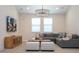 Well-lit living room featuring a modern chandelier, plush seating, and a stylish entertainment center at 8419 Pippen Dr, Orlando, FL 32836