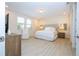 Bright main bedroom with light wood floors, a king-size bed, and ample natural light from the window at 8419 Pippen Dr, Orlando, FL 32836