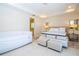 A main bedroom with tiled floors, neutral decor, a tray ceiling, and an adjacent bathroom at 8419 Pippen Dr, Orlando, FL 32836