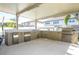 Outdoor kitchen with bar, sink, refrigeration, prep space, and high-end grill for gourmet cooking at 8419 Pippen Dr, Orlando, FL 32836