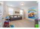 Bright playroom featuring light wood floors, a comfortable sofa, and fun Winnie the Pooh decorations at 8419 Pippen Dr, Orlando, FL 32836