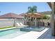 Inviting backyard pool with spa, sun loungers, covered bar and outdoor kitchen area for upscale entertaining at 8419 Pippen Dr, Orlando, FL 32836