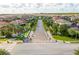 Scenic street view of a Primary-planned community with lush landscaping and well-maintained homes under a sunny, partly cloudy sky at 8419 Pippen Dr, Orlando, FL 32836